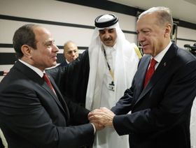 الرئيس المصري عبد الفتاح السيسي والرئيس التركي رجب طيب أردوغان يتصافحان على هامش افتتاح كأس العالم في الدوحة، ويبدو بينهما أمير قطر تميم بن حمد آل ثاني - الشرق/بلومبرغ