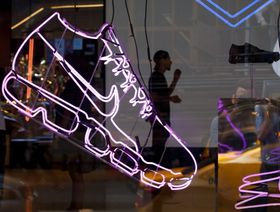 موظف لدى "نايكي" يظهر وراء واجهة متجر لها في سوهو في نيويورك. الشركة تعتبر التحقيق بشأنها الضريبي بلا أساس. - المصدر: بلومبرغ