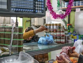 عميل يقدم أوراقا نقدية بالدينار التونسي في متجر دواجن وطعام في منطقة أريانة في تونس العاصمة، يوم الجمعة 8 أبريل 2022. - المصدر: بلومبرغ