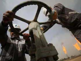 عاملان في إحدى منشآت الغاز في البصرة، العراق - المصدر: بلومبرغ