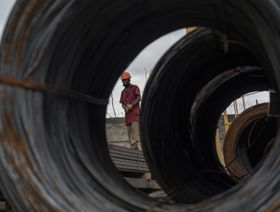 عامل يتأهب لتفريغ شحنة من العوارض الفولاذية من شاحنة في شركة "سوترال-سي آي" لتصنيع الصلب والألمنيوم، وهي جزء من مجموعة "يشي" بمنطقة يوبوغون الصناعية ببيدجان في ساحل العاج. - المصدر: بلومبرغ