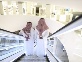 رجلان يستقلان سلم كهربائي أثناء تجولهما داخل مركز الملك عبد العزيز الثقافي العالمي في الظهران، المملكة العربية السعودية - المصدر: بلومبرغ