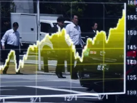 انعكاس للمشاة في لوحة إلكترونية تعرض رسماً بيانياً لسعر صرف الين مقابل الدولار الأميركي خارج شركة للأوراق المالية في طوكيو، اليابان - المصدر: بلومبرغ