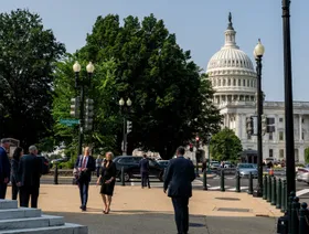 مارة وأشخاص وفي الخلفية يظهر مبنى الكابيتول في العاصمة واشنطن - بلومبرغ