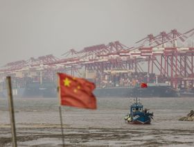 حاويات الشحن والأوناش خلف قارب صيد بالقرب من ميناء يانغشان في المياه العميقة في شنغهاي، الصين، يوم الأربعاء 6 ديسمبر 2023. - المصدر: بلومبرغ