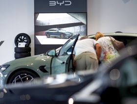 عملاء ينظرون إلى سيارات كهربائية في صالة عرض شركة "بي واي دي" - بلومبرغ