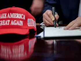 قبعة "اجعل أميركا عظيمة مرة أخرى" بينما يوقع الرئيس الأمريكي دونالد ترمب على أمر تنفيذي في المكتب البيضاوي بالبيت الأبيض في واشنطن العاصمة، الولايات المتحدة، 23 أبريل 2025. - بلومبرغ