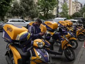 أحد عمال التوصيل في "غتير" أمام مستودع في إسطنبول، تركيا - بلومبرغ