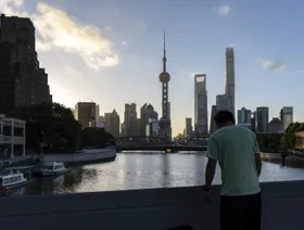 أحد المارة أمام المباني التجارية في منطقة لوجيازوي المالية في بودونغ في شنغهاي، الصين - بلومبرغ