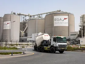 شاحنة تمر بجوار صوامع في مصنع الإمارات العالمية للألمنيوم في الطويلة بأبوظبي. - بلومبرغ