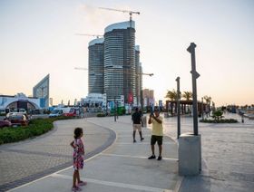 زوار يلتقطون صوراً أمام بوابة مهرجان العلمين الجديدة ومشروعات السكن في مدينة العلمين الجديدة، في محافظة مطروح، مصر، يوم الخميس، 24 أغسطس 2023 - المصدر: بلومبرغ