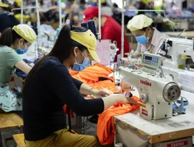 عمال ينكفئون على ماكينات خياطة داخل مصنع "تاي سون إس. بي." للملابس في مقاطعة بنه توان في فيتنام - المصدر: بلومبرغ