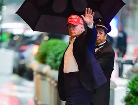 الرئيس الأميركي دونالد ترمب مرتدياً قبعة عليها شعار "لنجعل أميركا عظيمة مجدداً" - المصدر: بلومبرغ