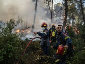 إطفائيون يكافحون حرائق الغابات بالقرب من مدينة ستاماتا، في شمال شرق أثينا، اليونان، بتاريخ 30 يونيو 2024 - المصدر: بلومبرغ