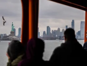 سياح يستقلون عبارة في جزيرة ستاتن في مدينة نيويورك - بلومبرغ