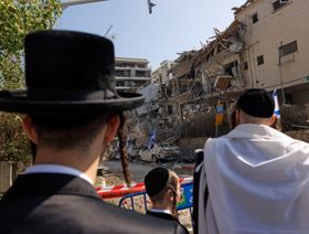 يهود أرثوذكس يتفقدون الأضرار التي لحقت بالمباني المستهدفة خلال هجوم بصواريخ باليستية شنته إيران، في مدينة رامات غان، إسرائيل - بلومبرغ