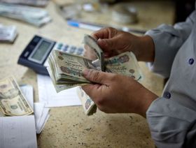 موظف يعد الأوراق النقدية بالجنيه المصري في مكتب صرف العملات الأجنبية في القاهرة، مصر. - المصدر: بلومبرغ