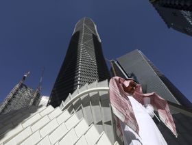 رجل بالزي الوطني السعودي يمر أمام مركز الملك عبدالله المالي الذي يضم مقرات بنوك محلية وأجنبية في العاصمة الرياض، المملكة العربية السعودية - المصدر: بلومبرغ