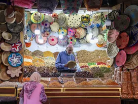 بائع في كشك يبيع الفواكه المجففة والمكسرات والسلال المنسوجة بالقرب من ساحة جامع الفنا والسوق في مراكش، المغرب - بلومبرغ