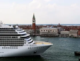 سفينة مبحرة وفي الخلفية عدد من المباني في مدينة البندقية، إيطاليا - المصدر: بلومبرغ