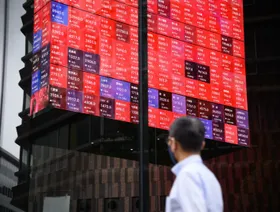 شخص ينظر إلى أسعار الأسهم على شاشة "المكعب الدوار" في ردهة مبنى كابوتو وان، بجوار بورصة طوكيو. طوكيو، اليابان، في 7 يونيو 2022. - المصدر: بلومبرغ