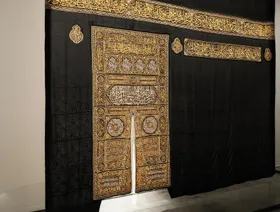 شخص يقف أمام كسوة للكعبة معروضة في بينالي الفنون الإسلامية في جدة، المملكة العربية السعودية - الشرق