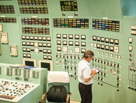 موظف يحمل جهازاً لوحياً في غرفة التحكم في محطة "باكس" للطاقة النووية، بالمجر - bloomberg
