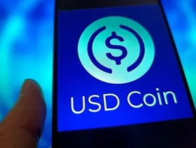 تصميم تخيلي لعملة مستقرة على شاشة هاتف محمول - بلومبرغ