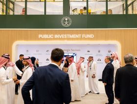 مجموعة من المستثمرين أمام لوحة تعرض القطاعات الاستراتيجية التي يستهدفها صندوق الاستثمارات العامة السعودي - الشرق/بلومبرغ