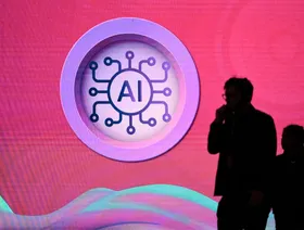 شخصان يمران بجوار تصميم على الجدار يحمل شعار الذكاء الاصطناعي - Getty Images