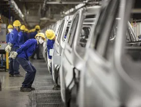 موظفون يتفحصون خط إنتاج سيارات - المصدر: بلومبرغ