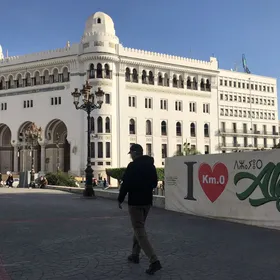 رجل يمشي على الرصيف في العاصمة الجزائرية. الحكومة تقرر زيادة الحد الأدنى للأجور والبطالة لتخفيف الأعباء على مواطنيها. - المصدر: بلومبرغ