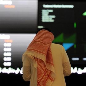 رجل بالزي الوطني السعودي يتابع حركة الأسهم على لوحة إلكترونية في سوق الأسهم السعودية، الرياض، المملكة العربية السعودية - المصدر: بلومبرغ