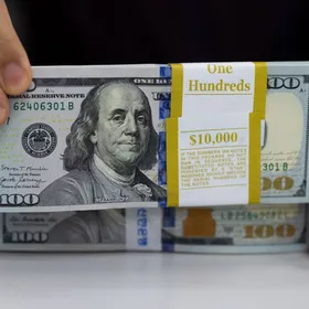 حزم أوراق نقدية فئة 100 دولار أميركي - المصدر: بلومبرغ