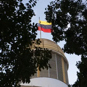 علم فنزويلا يرفرف فوق مبنى الجمعية الوطنية خلال الانتخابات البرلمانية في كاراكاس، فنزويلا - المصدر: بلومبرغ