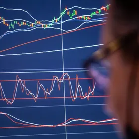 متداول ينظر إلى شاشة تعرض حركة الأسهم - المصدر: بلومبرغ