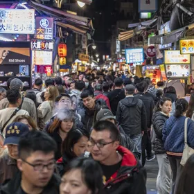 مشاة يسيرون في سوق شي لين الليلي في تايبيه عاصمة تايوان - بلومبرغ