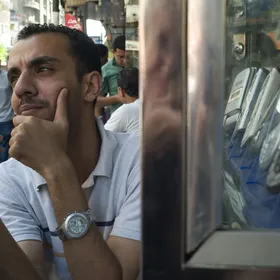 شاب يختبر هاتفاً محمولاً بجانب متجر لبيع أجهزة الاتصالات في القاهرة، مصر - المصدر: بلومبرغ