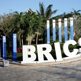 شعار مجموعة بريكس (BRICS) ولافتات تحمل أعلام الدول الأعضاء في المجموعة - المصدر: بلومبرغ