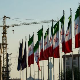 تصطف الأعلام الوطنية لإيران على جزء من طريق هاشمي رفسنجاني السريع حيث تقف رافعة البناء خلفه في طهران، إيران - المصدر: بلومبرغ