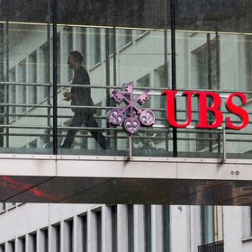 شخص يمر بين المكاتب بينما يوجد شعار بنك "يو بي إس" على ممر في مقره الرئيسي في زيورخ، سويسرا - بلومبرغ