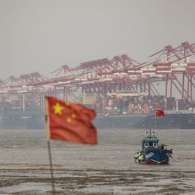 حاويات الشحن والأوناش خلف قارب صيد بالقرب من ميناء يانغشان في المياه العميقة في شنغهاي، الصين، يوم الأربعاء 6 ديسمبر 2023. - المصدر: بلومبرغ