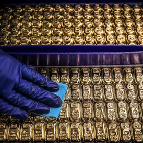 موظف يمسح سبائك الذهب في إحدى مصافي المعدن النفيس - AFP