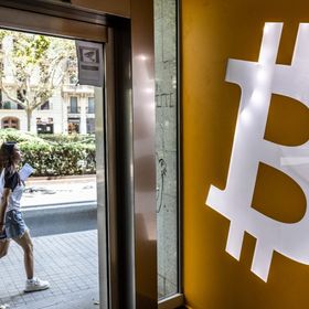 شعار بتكوين في إحدى منصات تداول العملات المشفّرة في برشلونة. - بلومبرغ