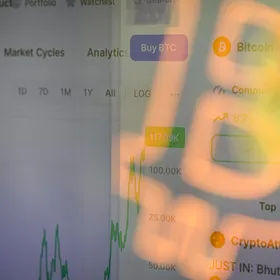 شعار بتكوين ينعكس على شاشة تعرض رسماً بيانياً لتداول العملات المشفرة - بلومبرغ