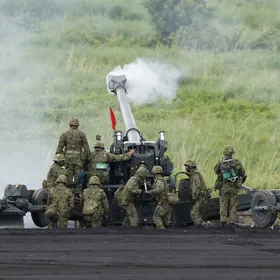 أفراد من قوات الدفاع الذاتي البرية اليابانية يشغّلون مدفع هاوتزر ميداني من طراز FH70 عيار 155 ملم خلال تدريب بالذخيرة الحية في غوتيمبا عام 2024 - بلومبرغ