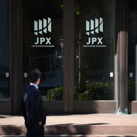 شخص ينظر إلى بوابة بورصة طوكيو، التي تديرها شركة 'جابان إكستشنغ غروب'، معروضة خارج البورصة في طوكيو، اليابان - المصدر: بلومبرغ