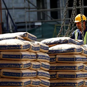 عامل يرتدي معدات السلامة، يشرف على تحميل أكياس أسمنت من صناعة شركة "أسمنت الرياض" بواسطة رافعة في موقع إنشاءات، الرياض، السعودية - رويترز