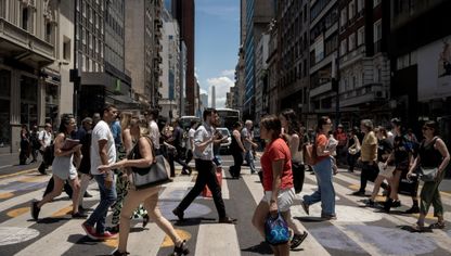 مشاة يعبرون شارع كورينتس في بوينس آيرس، الأرجنتين - المصدر: بلومبرغ