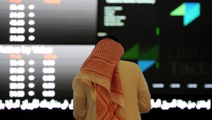 رجل بالزي التقليدي السعودي يتابع حركة الأسهم على لوحة إلكترونية في سوق الأسهم السعودية. الرياض. المملكة العربية السعودية (صورة أرشيفية) - المصدر: بلومبرغ